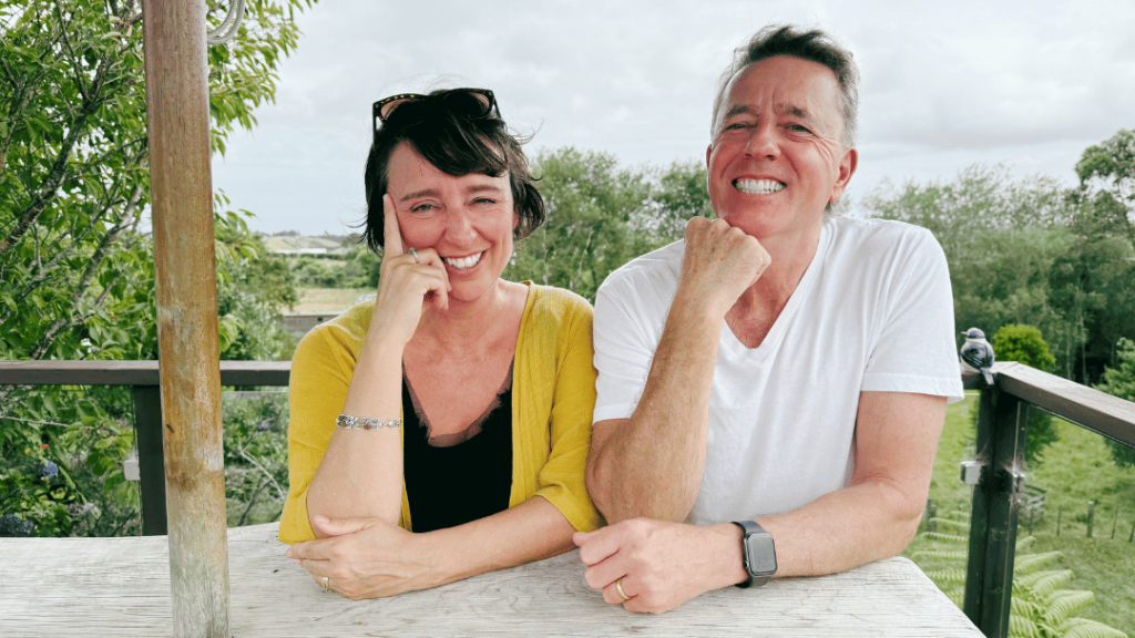 A husband and wife siting in New Zealand, talking non their podcast, NZ Ahead, about life in NZ