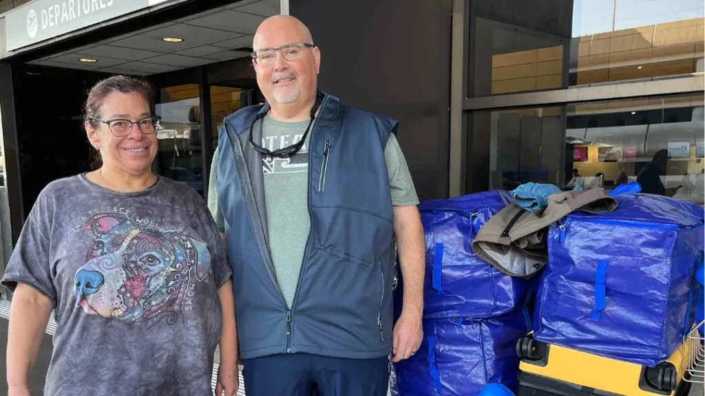 A couple at an airport making the move from America to New Zealand. Here they are interviewed on The NZ Ahead Podcast